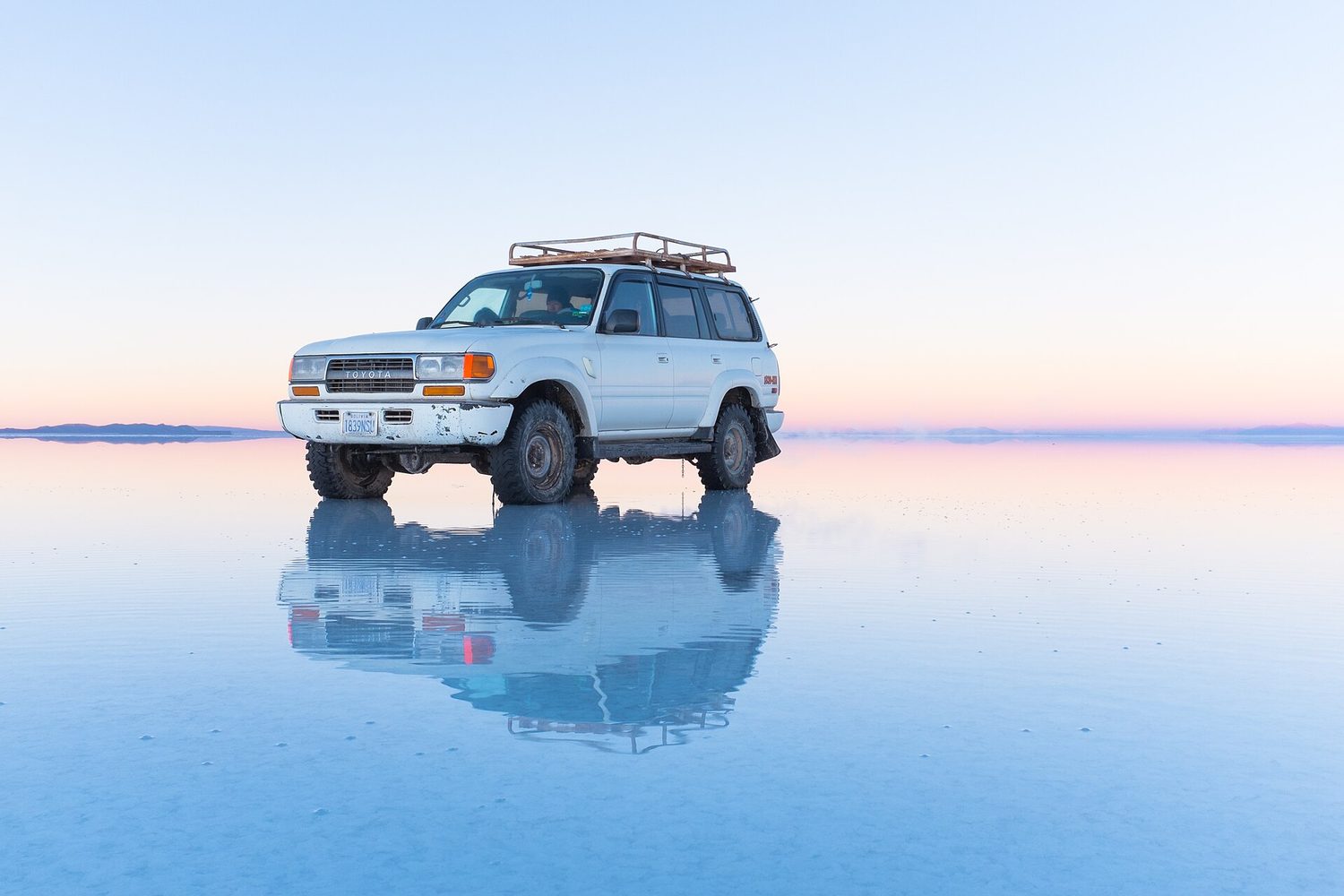 Vehículo sobre el espejo de agua del Salar de Uyuni
